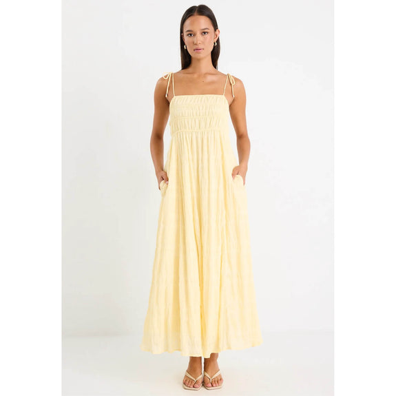 Woman wearing a light yellow dress on a white background