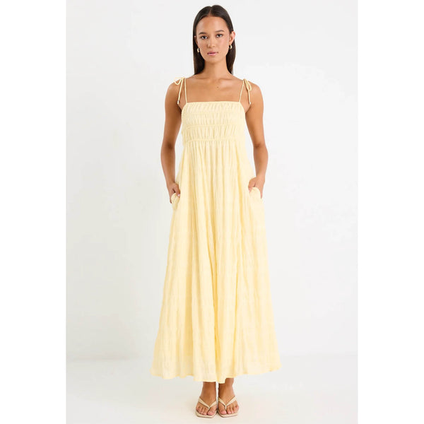 Woman wearing a light yellow dress on a white background