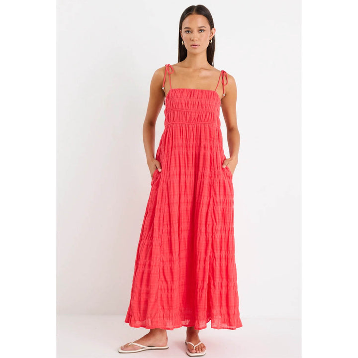 Woman wearing a coral dress against a white background