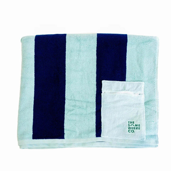 Teal towel with navy stripes and a smaller white towel with 'The Same Here Co' logo on a white background
