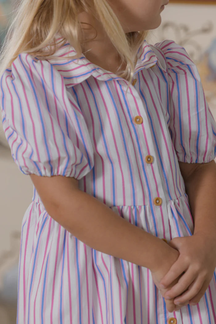 Child wearing a striped dress with a blurred background