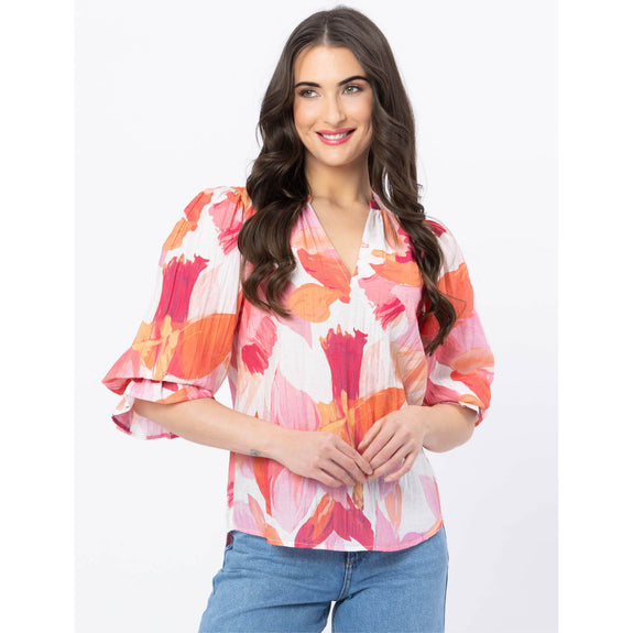 Woman wearing a colorful floral blouse with a white background