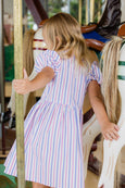Child in a striped dress on a carousel