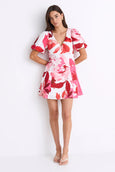 Woman wearing a red and white floral dress on a white background