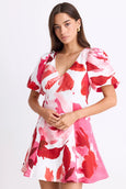 Woman wearing a red and white floral dress on a white background