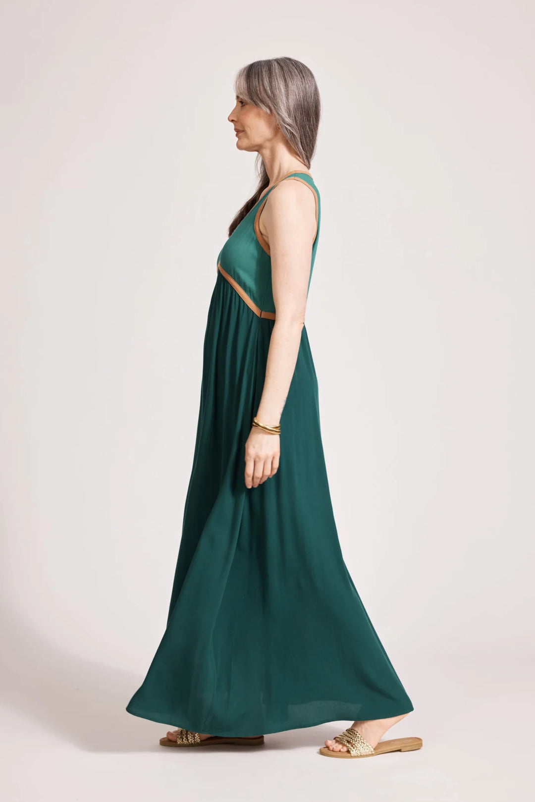Woman wearing a green Eb & Ive dress with cut-out design on a white background