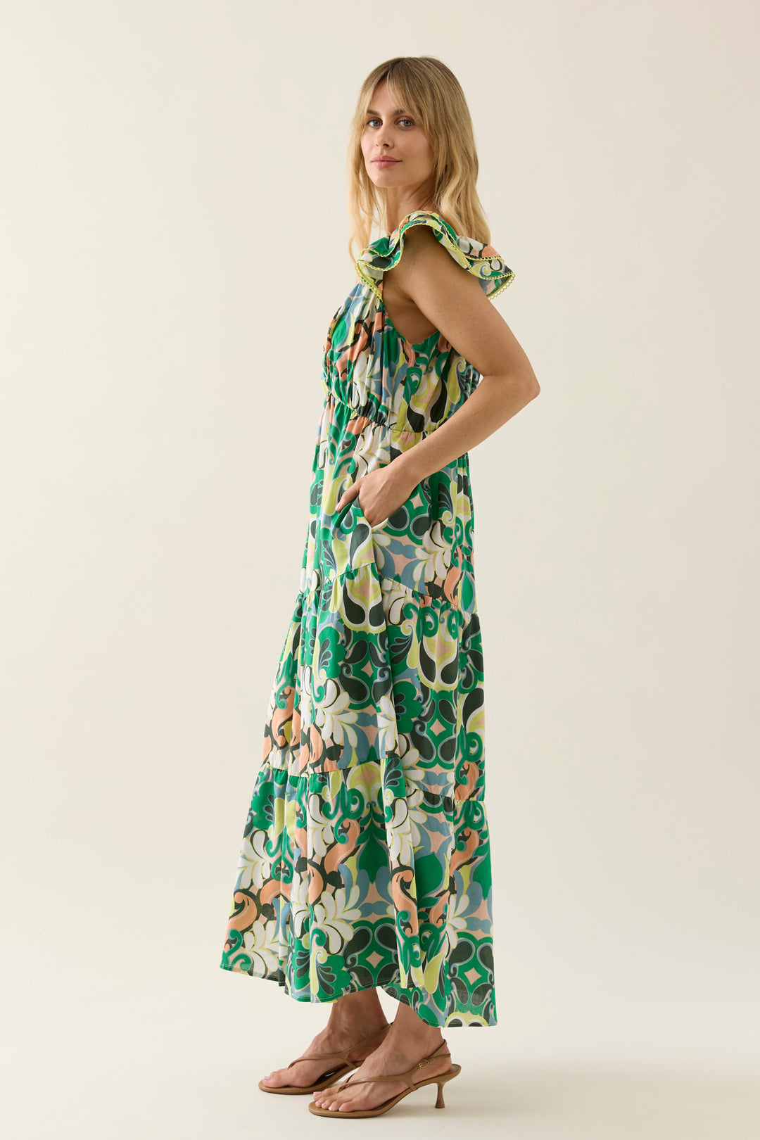 Woman wearing a floral isle of mine dress on a plain background