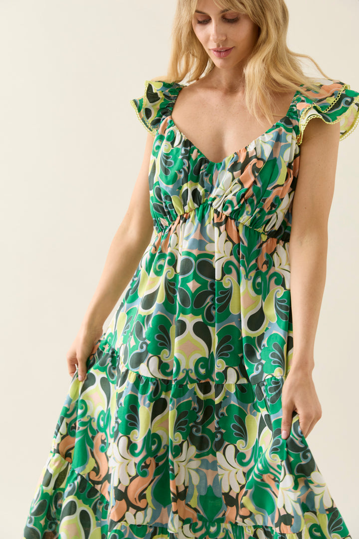 Woman wearing a colorful patterned isle of mine dress against a plain background