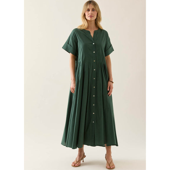 Woman wearing a green isle of mine dress with buttons on a white background