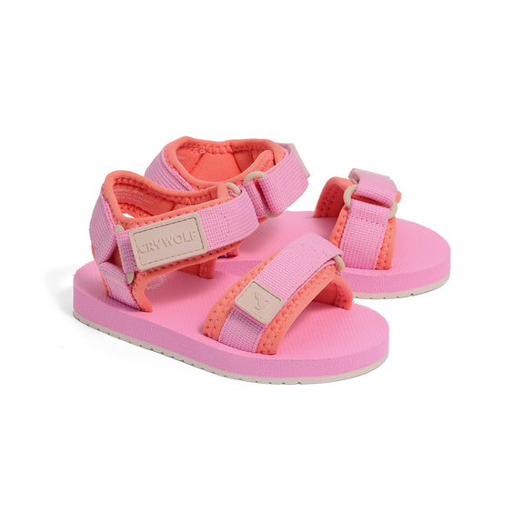 Pink and coral crywolf beach sandals with ' crywolf' branding on a white background