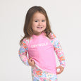 Child wearing crywolf pink and floral rash vest with 'Crywolf' text on a white background