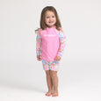 Child wearing a pink 'Crywolf' rash vest with floral sleeves and shorts on a white background