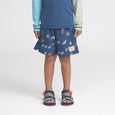 Child wearing a crywolf blue patterned rash vest and board shorts with sandals on a white background