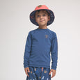 Child wearing a blue long-sleeve rash vest and colorful pants with a hat on a white background
