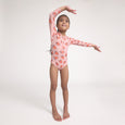 Young girl in a pink crywolf swimsuit with strawberry pattern on a white background
