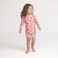 Crywolf Child wearing a pink onesie with strawberry pattern on a white background