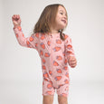 Crywolf Child wearing a pink strawberry-patterned onesie on a white background