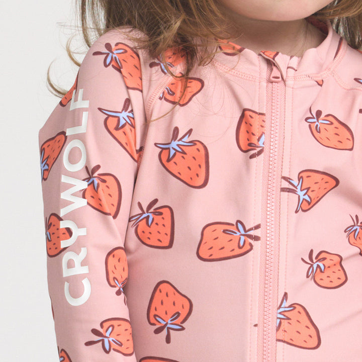 Crywolf Pink children's rash suit with strawberry pattern and 'Crywolf' branding on a light background