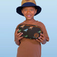 Child holding a dinosaur-themed pouch against a light blue background