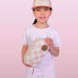 Child holding a pink and white checkered pouch against a pink background