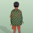 Person wearing a green checkered backpack on a light green background