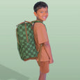 Child wearing a green checkered backpack on a light green background