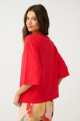 Woman wearing a red oversized shirt on a white background