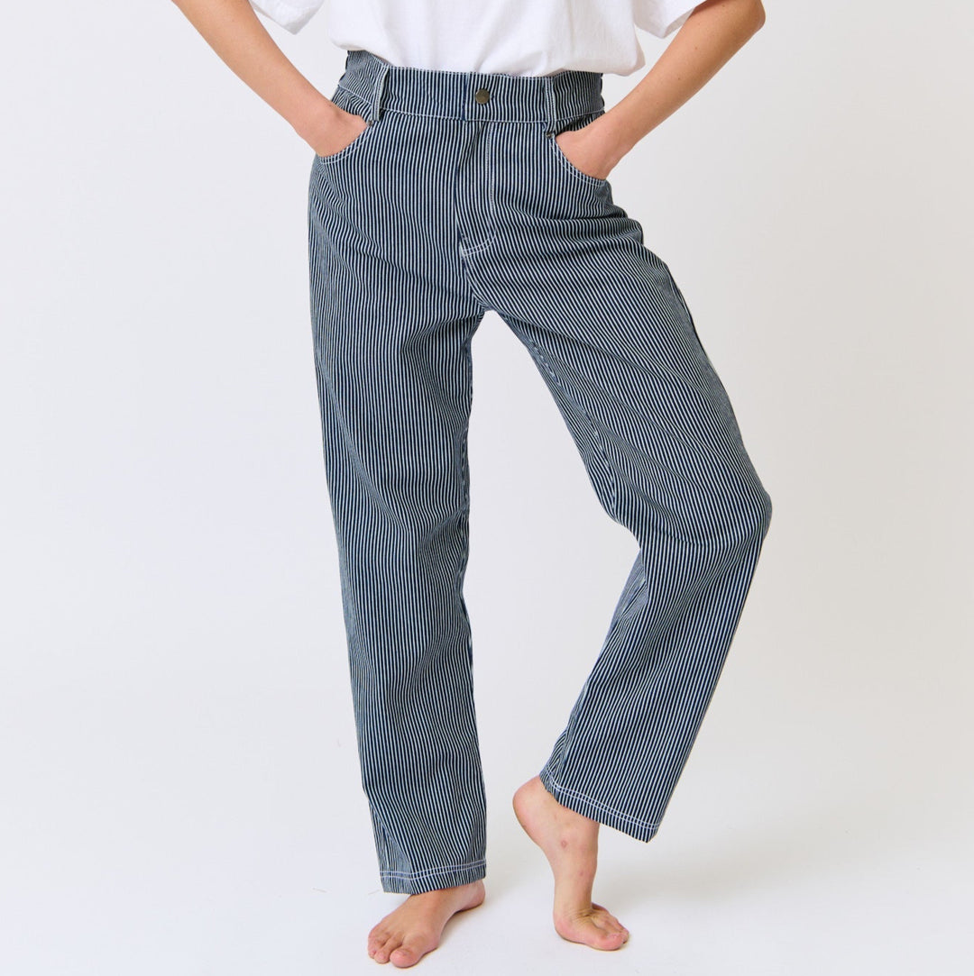 Person wearing a white t-shirt with a red heart design and blue jeans on a white background
