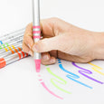 Hand holding a pink marker over colorful lines on a white background