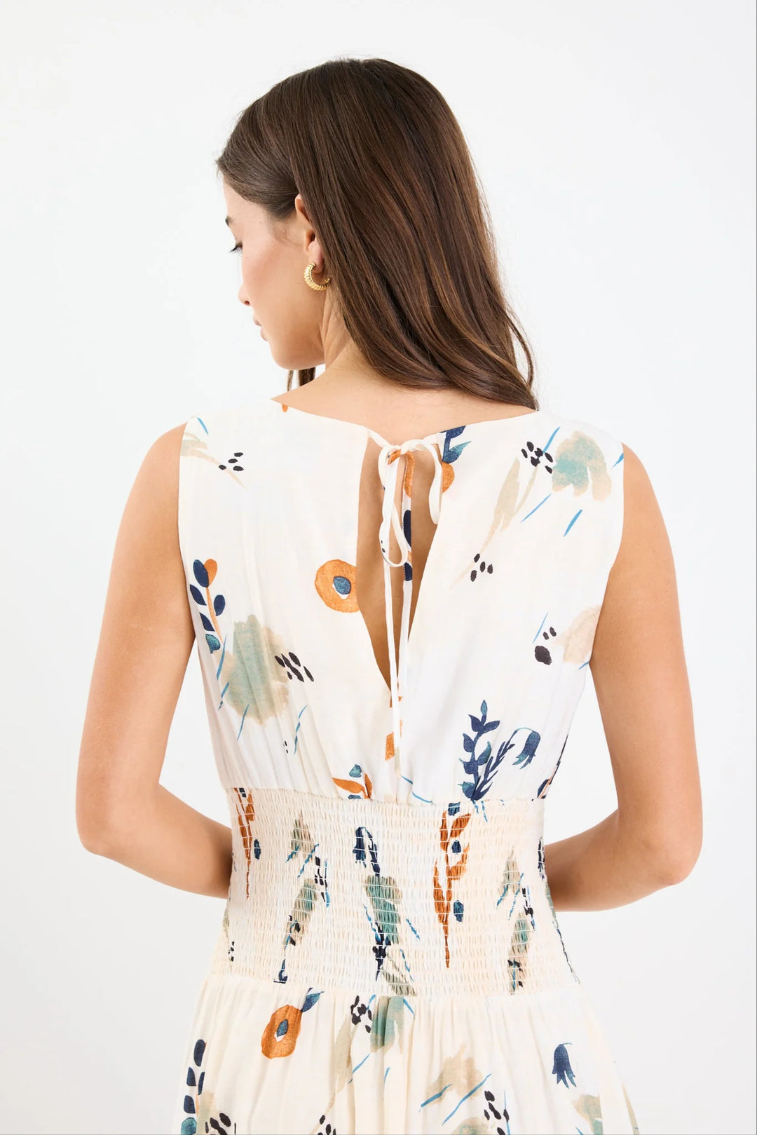 Woman wearing a sleeveless dress with floral pattern on a white background