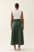 Person wearing a white top and green isle of mine skirt on a plain background