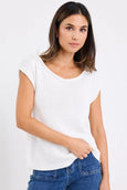 Woman wearing a white top and blue jeans on a plain background