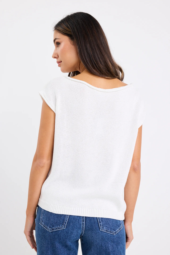 Woman wearing a white top and blue jeans on a plain background