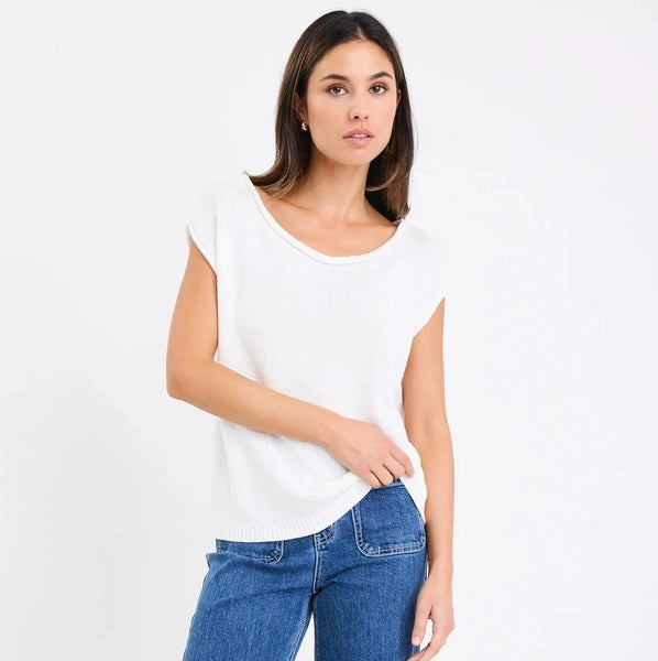 Woman wearing a white top and blue jeans on a white background