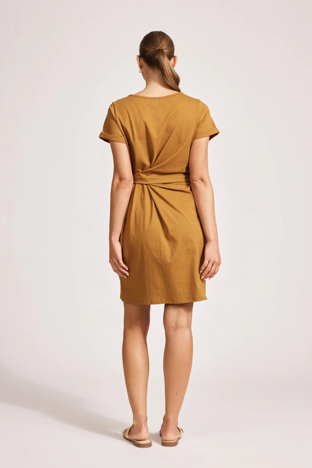 Woman wearing a eb & ive mustard yellow dress on a white background