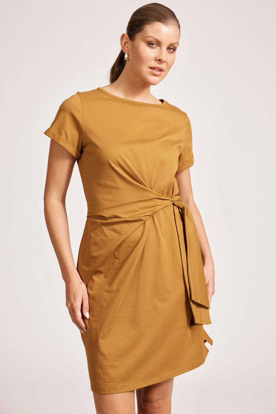 Woman wearing a eb & ive mustard yellow dress on a white background