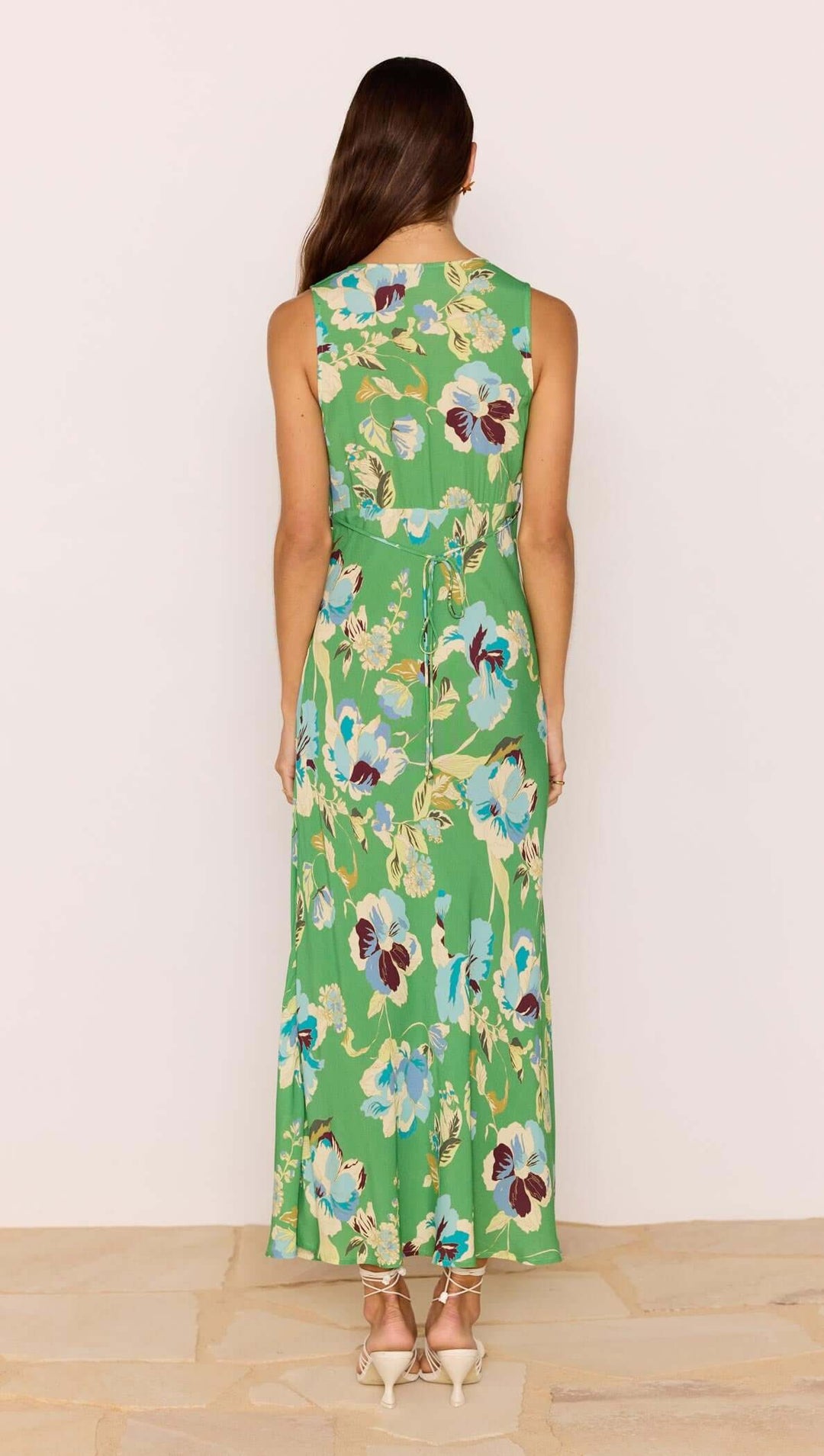 Woman wearing a green floral dress against a white background
