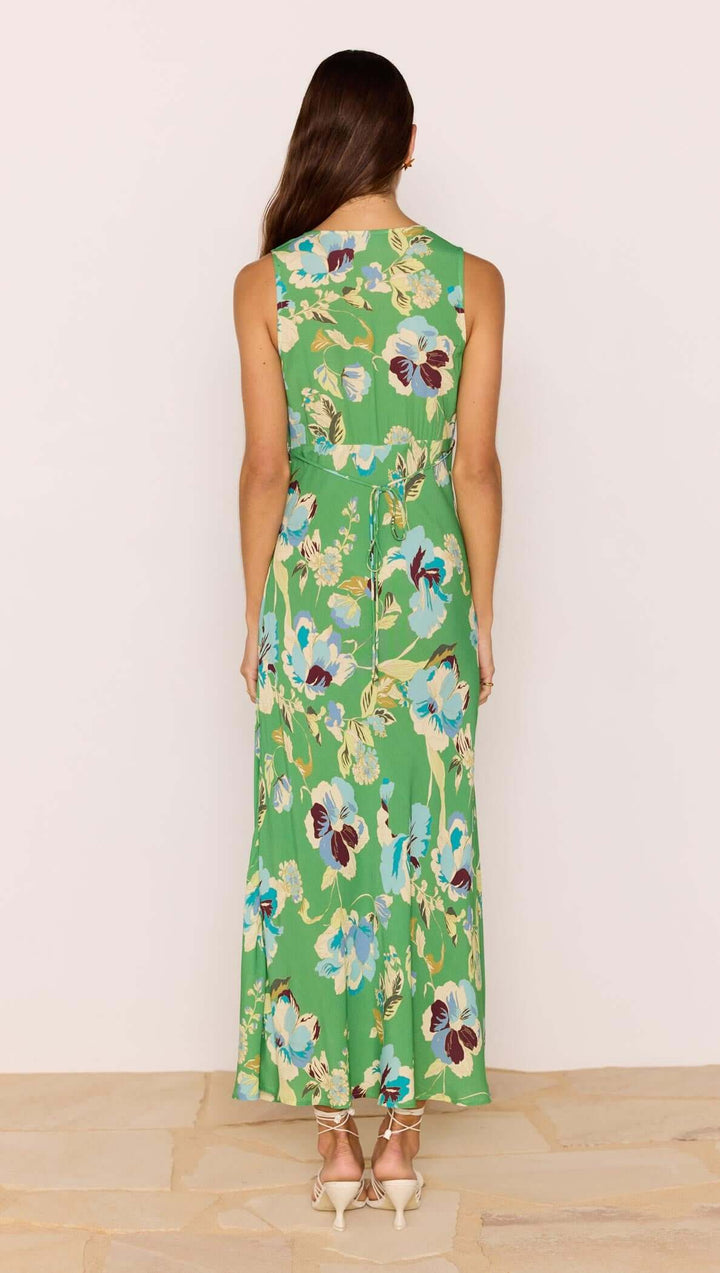 Woman wearing a green floral dress against a white background