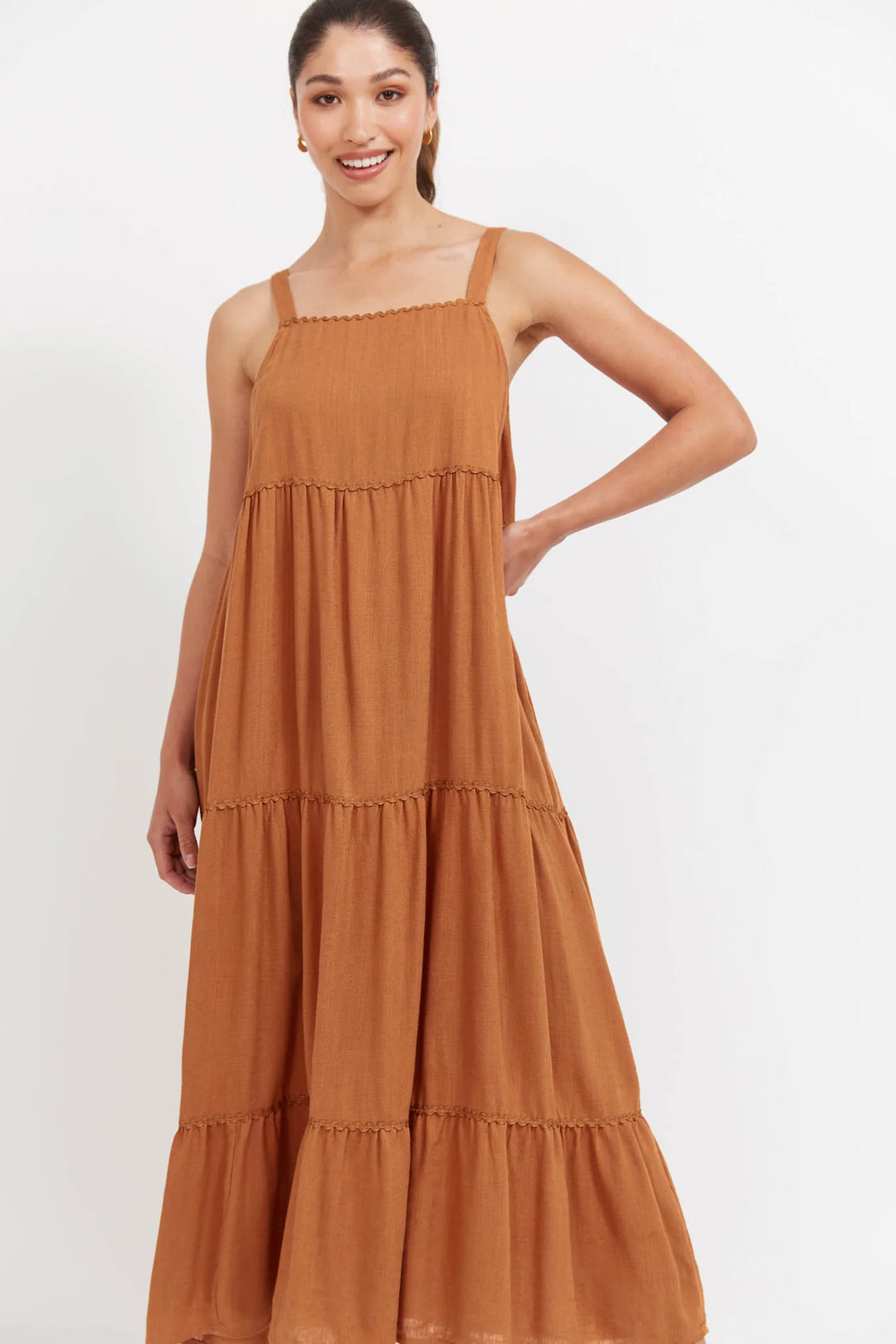 Woman wearing a Haven brown tiered dress on a white background