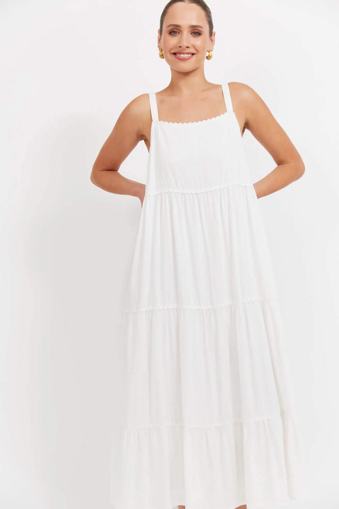 Woman wearing a white haven dress against a plain background