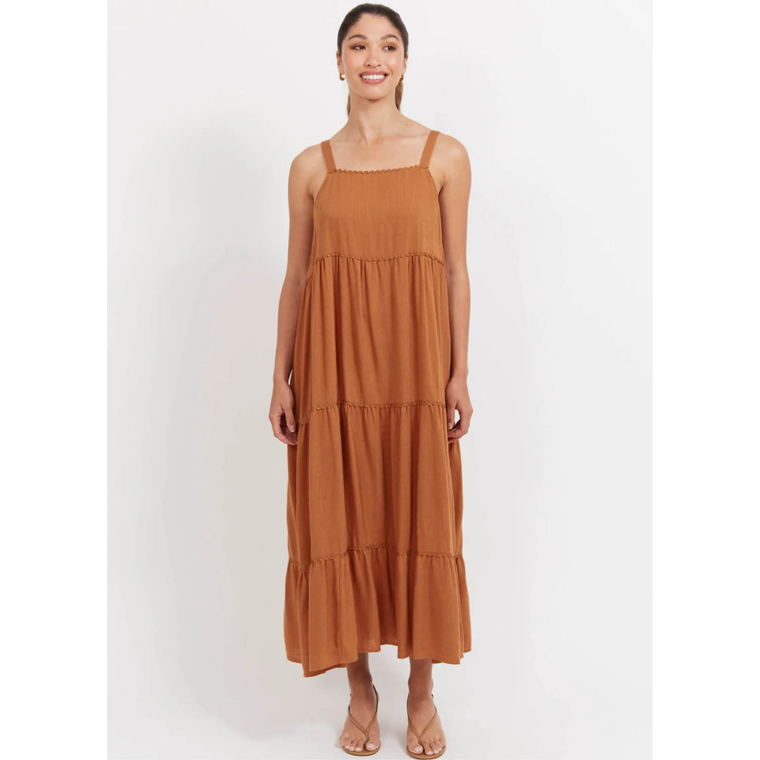 Woman wearing a Haven brown tiered dress on a white background
