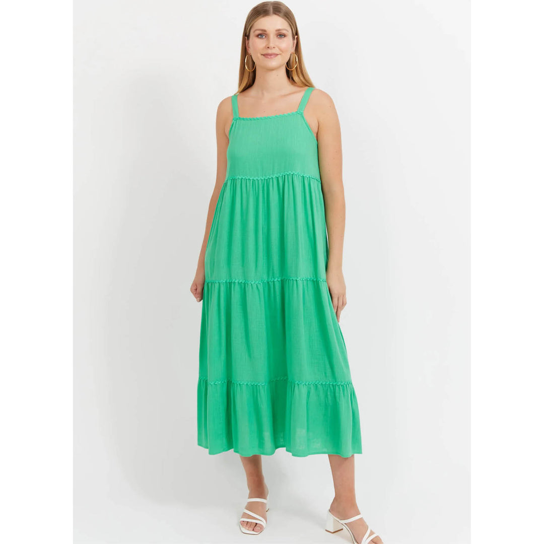 Woman wearing a green Haven dress on a white background