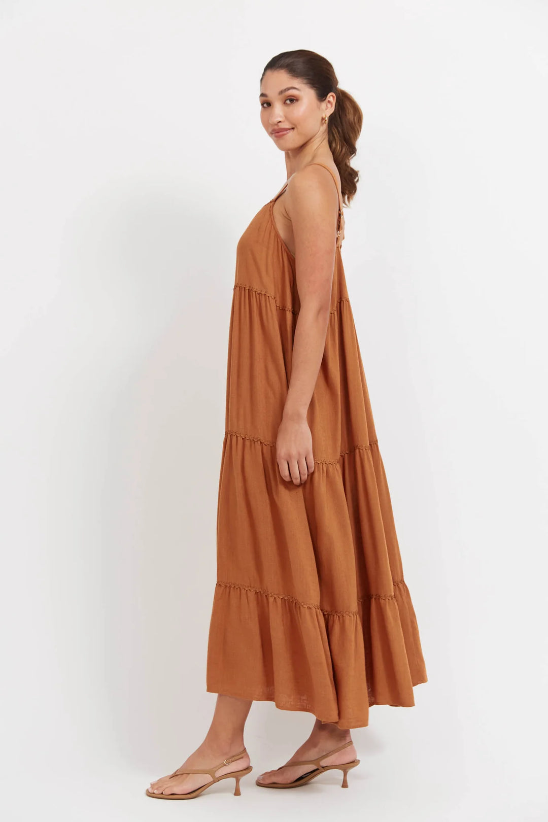 Woman wearing a Haven brown tiered dress on a white background