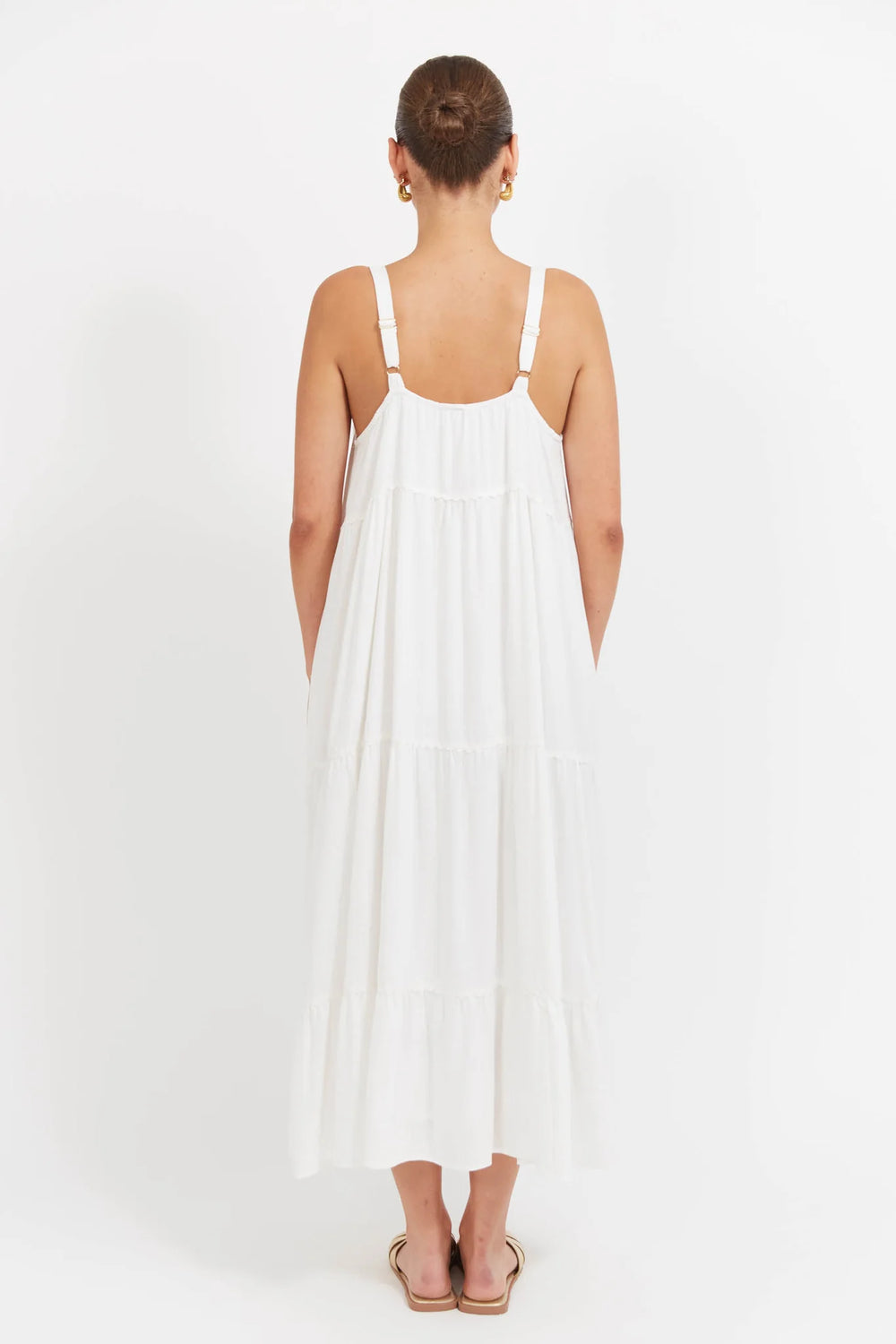 Woman wearing a Haven white dress with thin straps on a white background