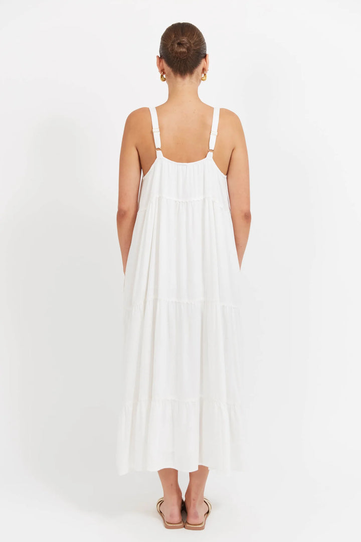 Woman wearing a Haven white dress with thin straps on a white background