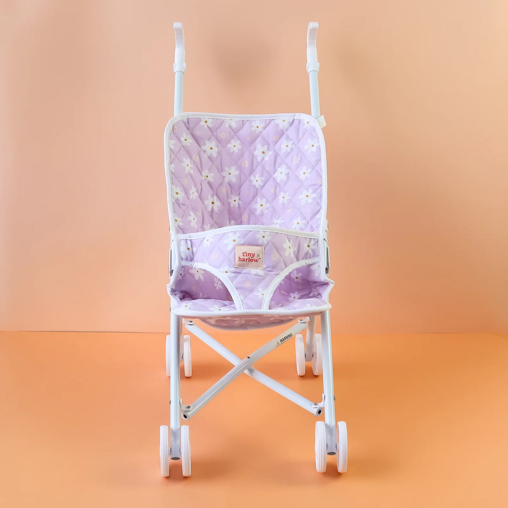 Tiny Harlow Purple floral-patterned dolls stroller against an orange gradient background