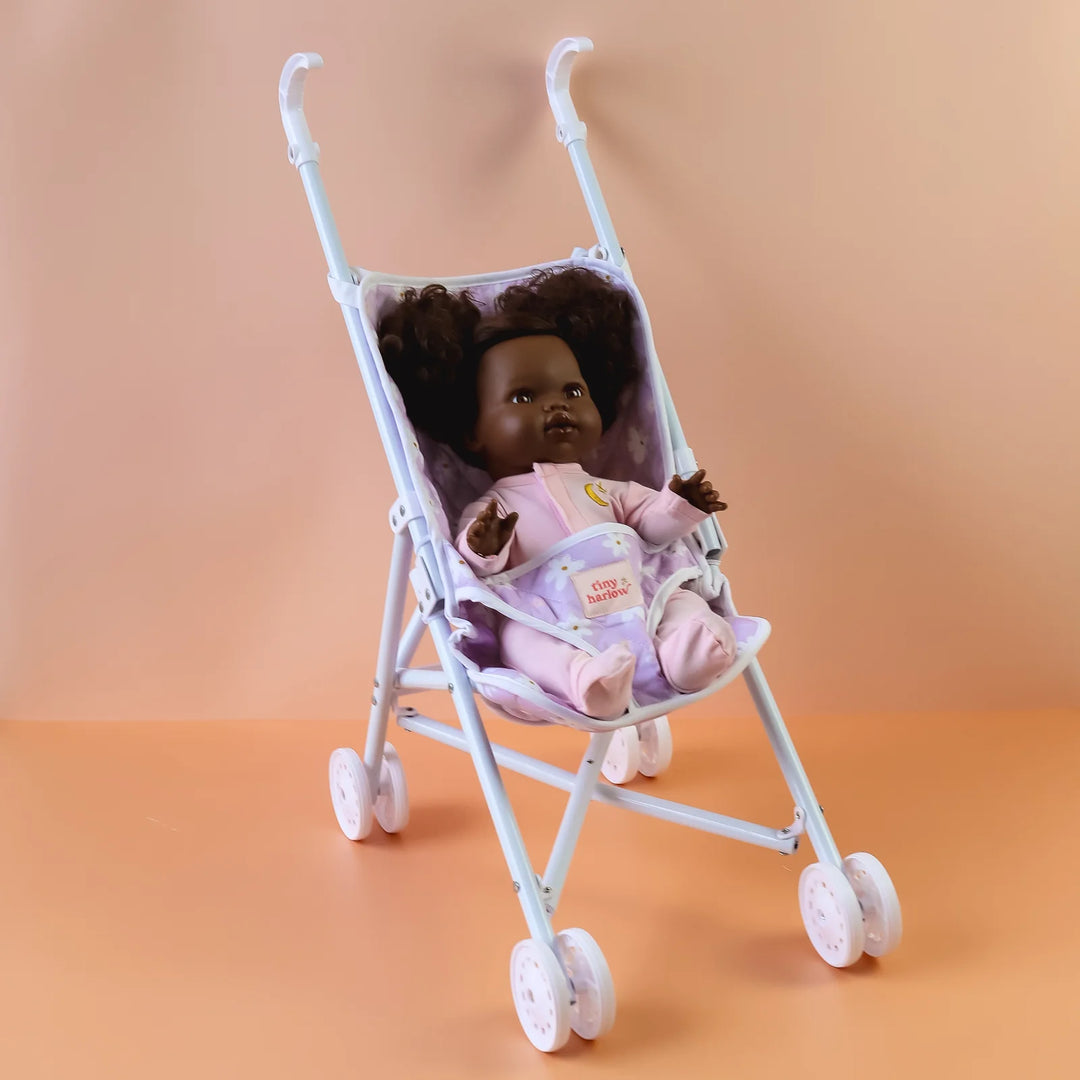 Tiny Harlow Purple floral-patterned dolls stroller against an orange gradient background
