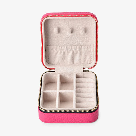 Pink jewelry case with earrings on a white background
