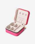 Pink jewelry case with earrings and rings on a white background