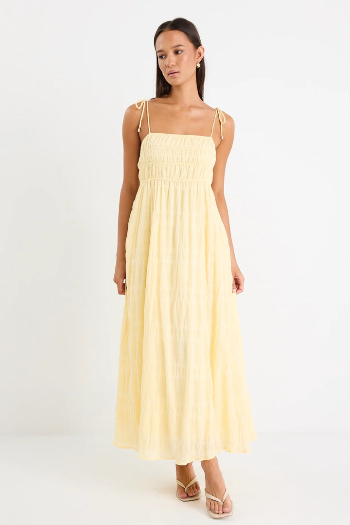Woman wearing a light yellow dress on a white background